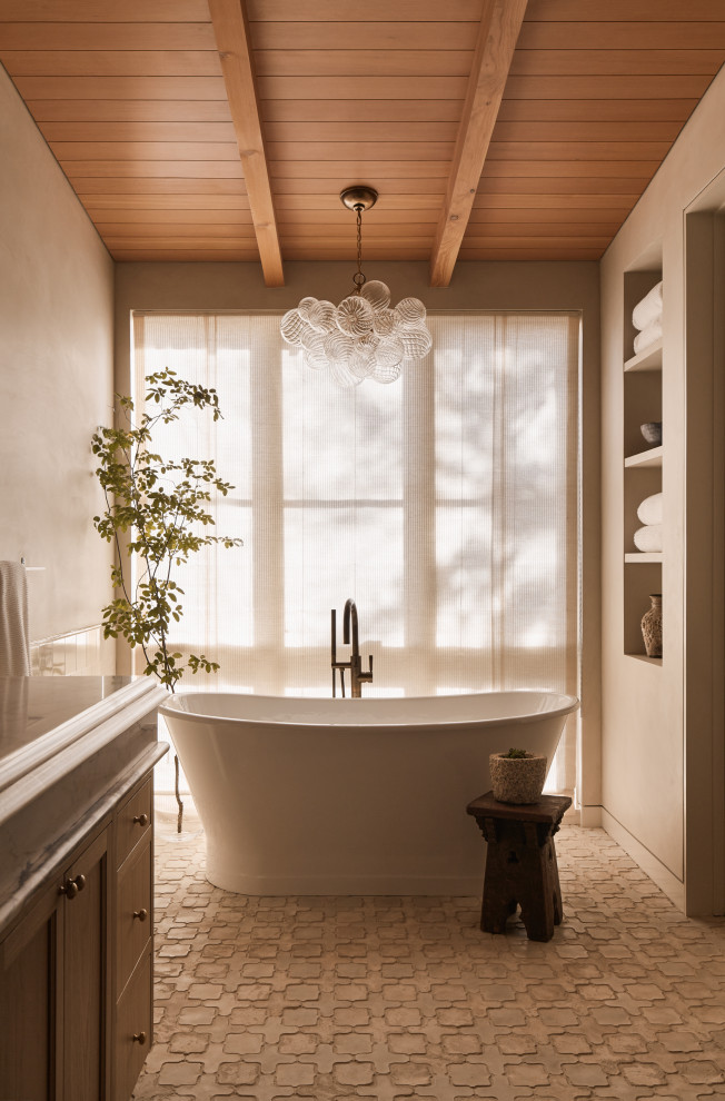 Hill Country Village Legacy Home - Inspiration for a large transitional master beige tile and ceramic tile cement tile floor, white floor, double-sink and exposed beam freestanding bathtub remodel in Austin with beaded inset cabinets, beige cabinets, a two-piece toilet, beige walls, an undermount sink, marble countertops, a hinged shower door, white countertops and a built-in vanity