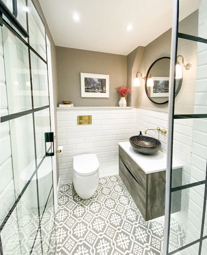 Inspiration för små eklektiska vitt badrum med dusch, med släta luckor, grå skåp, en kantlös dusch, en vägghängd toalettstol, vit kakel, tunnelbanekakel, grå väggar, cementgolv, ett fristående handfat, marmorbänkskiva, grått golv och dusch med gångjärnsdörr