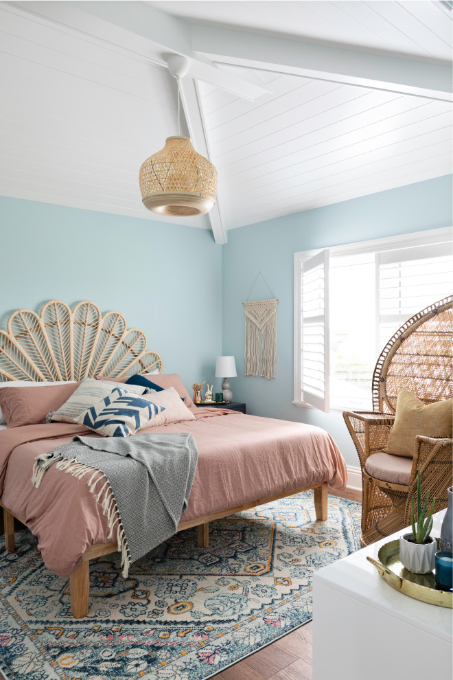 タンパにあるビーチスタイルのおしゃれな寝室 (青い壁、無垢フローリング、茶色い床、塗装板張りの天井、三角天井)