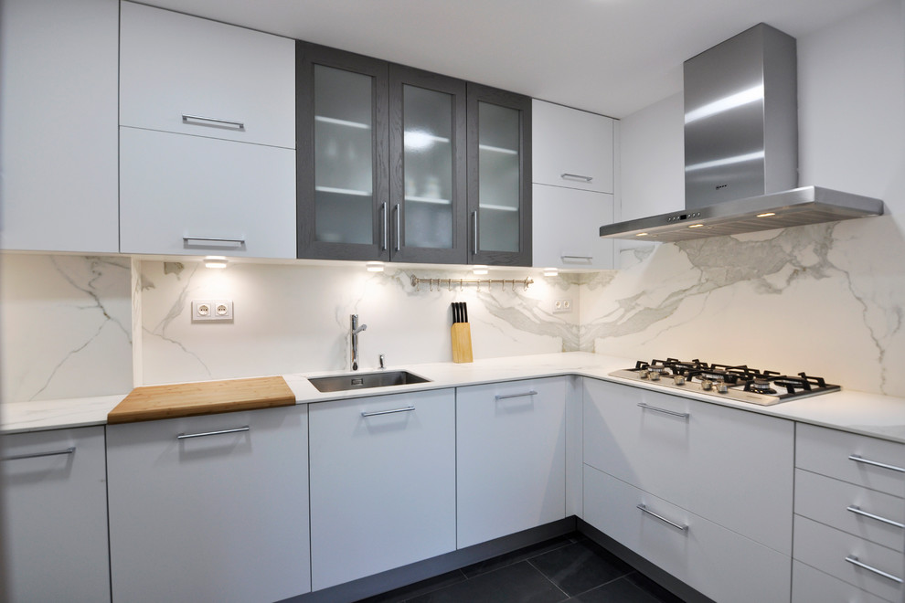 Photo of a mid-sized contemporary u-shaped separate kitchen in Barcelona with an undermount sink, recessed-panel cabinets, white cabinets, quartzite benchtops, white splashback, ceramic splashback, stainless steel appliances, porcelain floors and no island.
