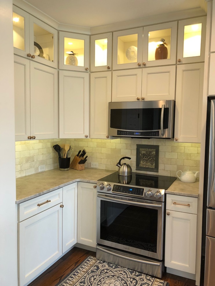 Inspiration for a large transitional dark wood floor and brown floor open concept kitchen remodel in Omaha with an undermount sink, recessed-panel cabinets, beige cabinets, quartz countertops, beige backsplash, stone tile backsplash, stainless steel appliances, an island and beige countertops