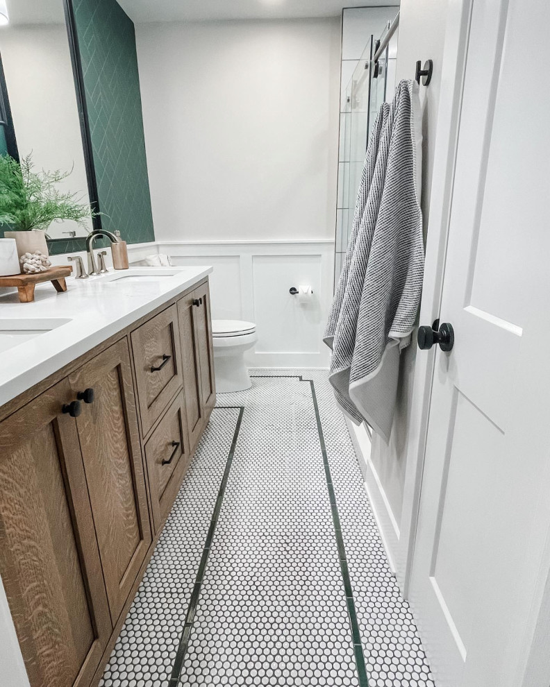 This is an example of a medium sized rural ensuite bathroom in Chicago with shaker cabinets, medium wood cabinets, an alcove shower, a two-piece toilet, white tiles, porcelain tiles, green walls, ceramic flooring, a submerged sink, engineered stone worktops, yellow floors, a sliding door, white worktops, a wall niche, double sinks, a built in vanity unit and wallpapered walls.