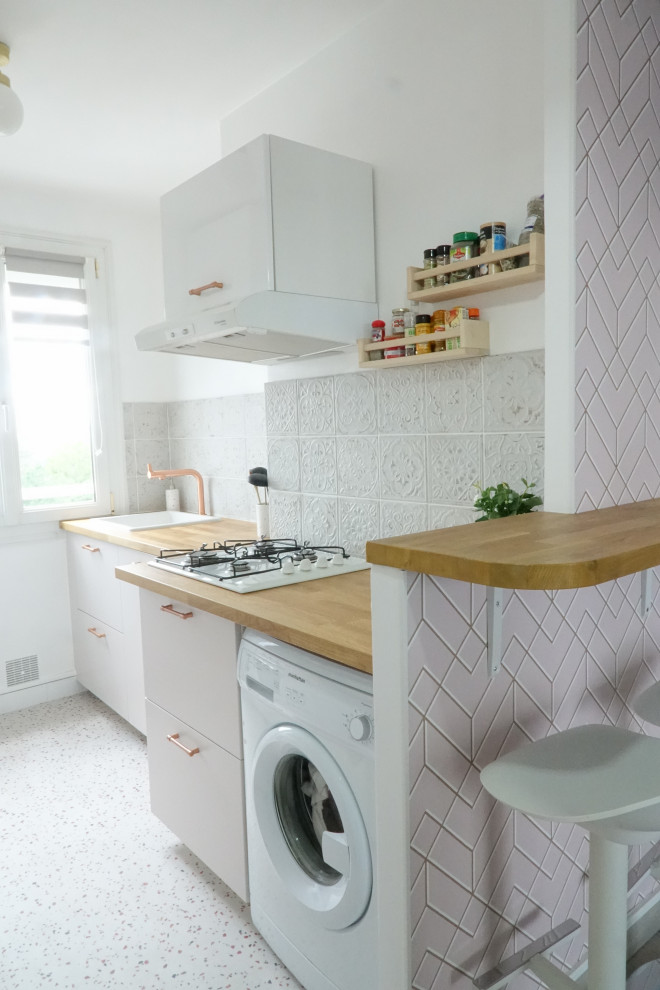 Design ideas for a mid-sized modern galley eat-in kitchen in Other with an undermount sink, beaded inset cabinets, pink cabinets, wood benchtops, white splashback, ceramic splashback, white appliances, terrazzo floors, a peninsula, beige floor and beige benchtop.