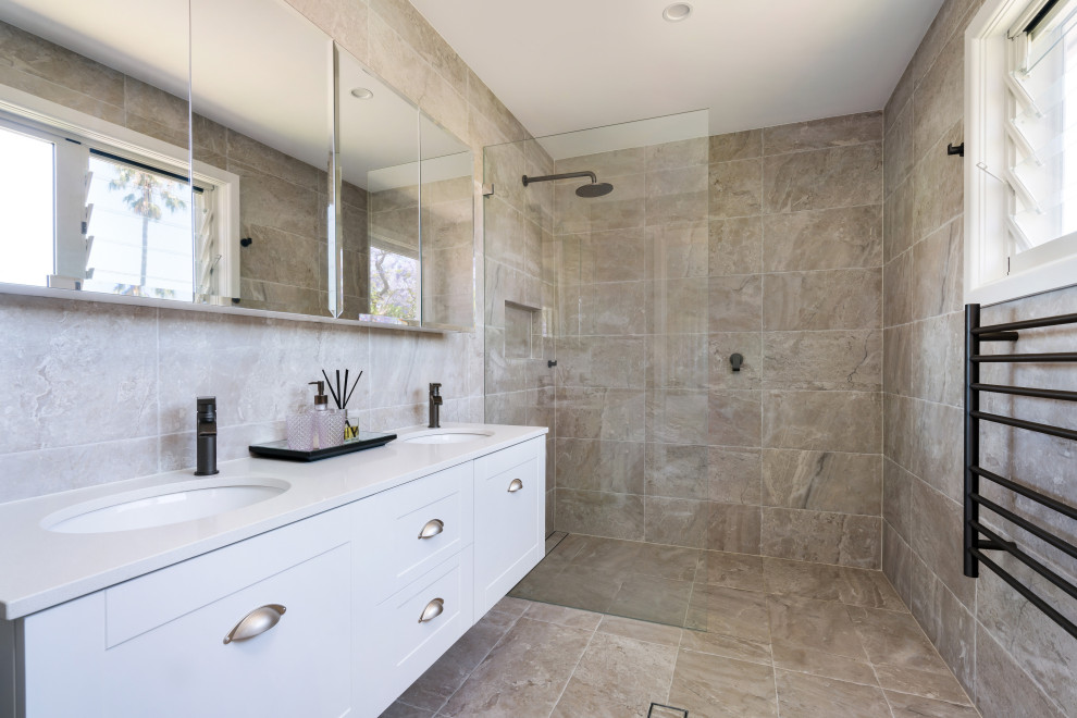 This is an example of a contemporary bathroom in Sydney with shaker cabinets, white cabinets, a curbless shower, beige tile, an undermount sink, beige floor, an open shower, white benchtops and a double vanity.