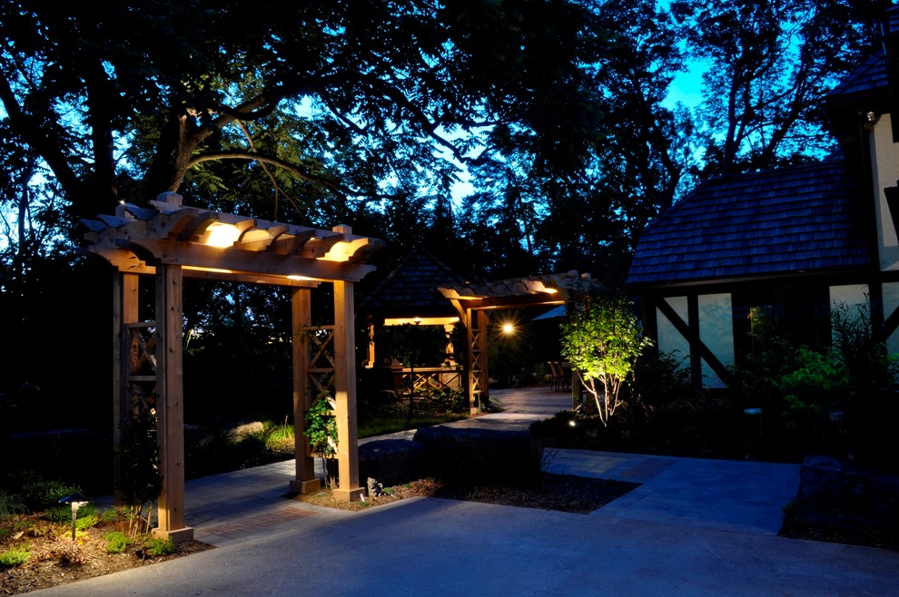 Design ideas for a large traditional side yard patio in Toronto with concrete pavers and a pergola.