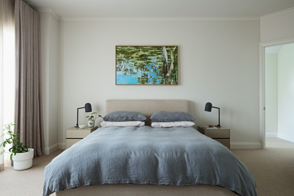 Large contemporary bedroom in Melbourne with white walls, carpet and beige floor.