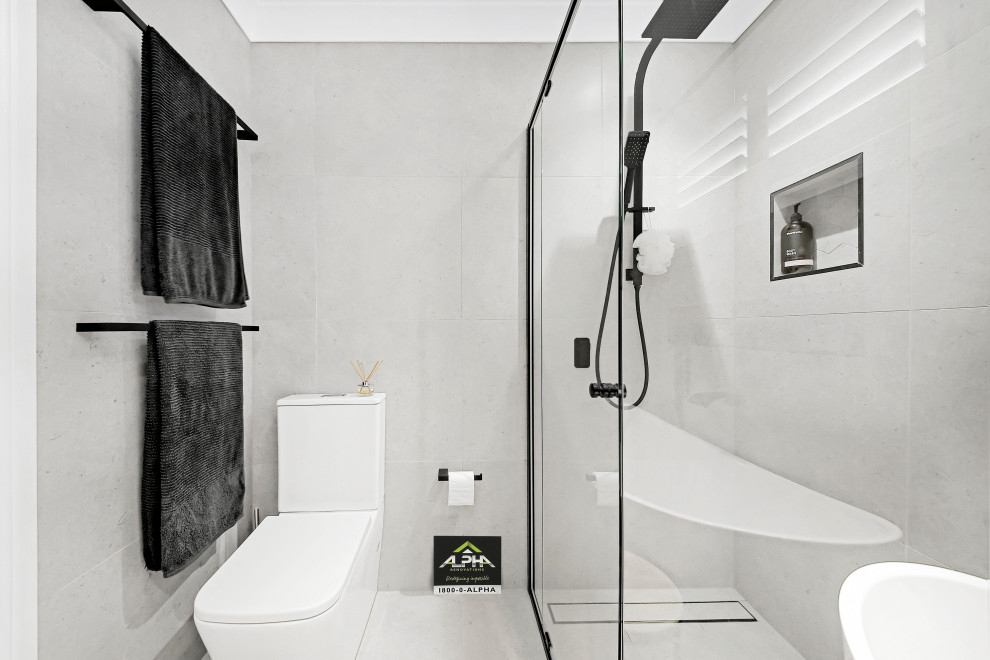 Small modern 3/4 bathroom in Sydney with flat-panel cabinets, white cabinets, a corner shower, a one-piece toilet, white tile, porcelain tile, white walls, porcelain floors, a console sink, engineered quartz benchtops, white floor, a sliding shower screen, white benchtops, a niche, a single vanity and a freestanding vanity.
