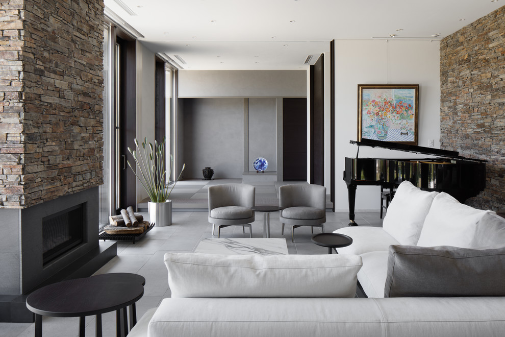 Contemporary living room in Other with multi-coloured walls, concrete floors, grey floor and a standard fireplace.