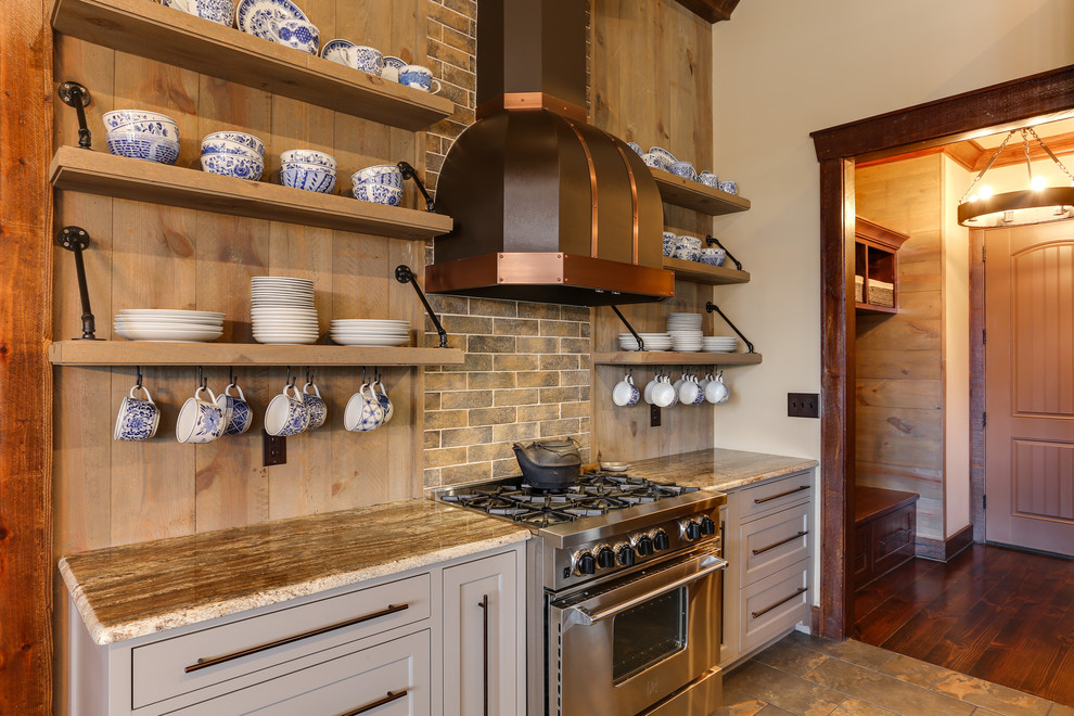 Inspiration for a large country u-shaped kitchen in Raleigh with brown splashback, ceramic floors, with island, a farmhouse sink, beaded inset cabinets, grey cabinets, granite benchtops, stone tile splashback, stainless steel appliances and brown floor.