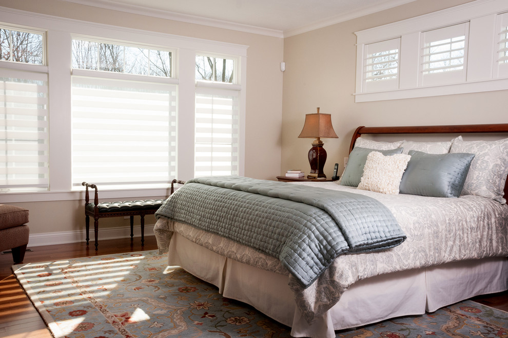 Example of a mid-sized classic master medium tone wood floor and brown floor bedroom design with beige walls