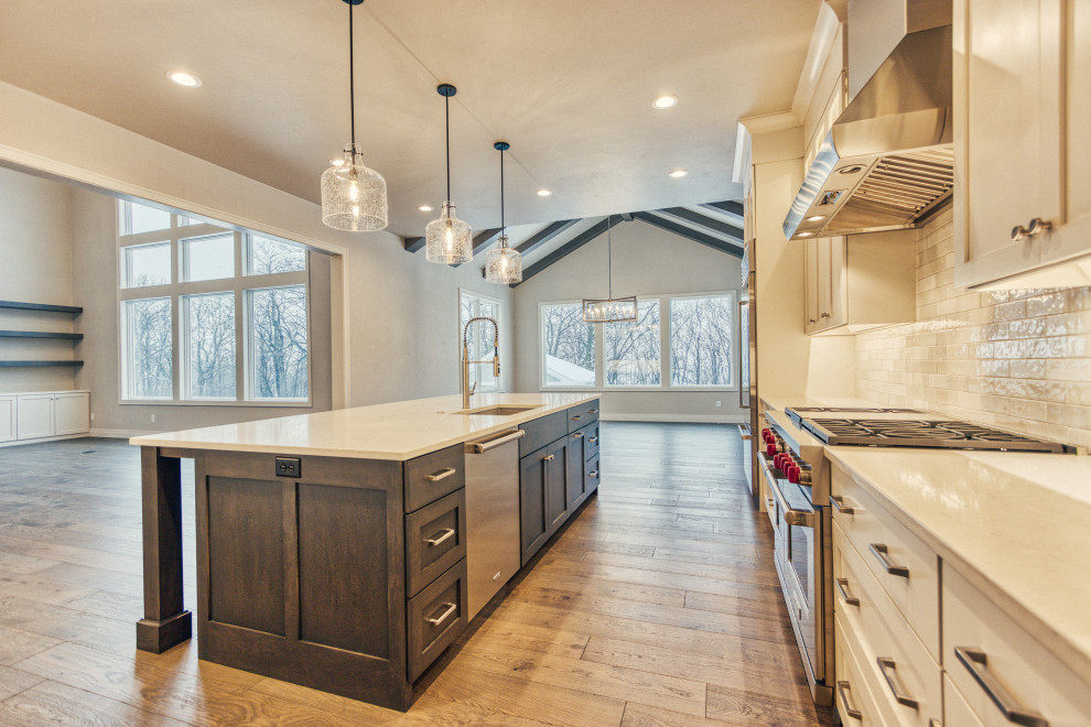 Kitchen pantry - large transitional l-shaped medium tone wood floor and brown floor kitchen pantry idea with an undermount sink, shaker cabinets, white cabinets, quartz countertops, white backsplash, ceramic backsplash, stainless steel appliances, an island and white countertops
