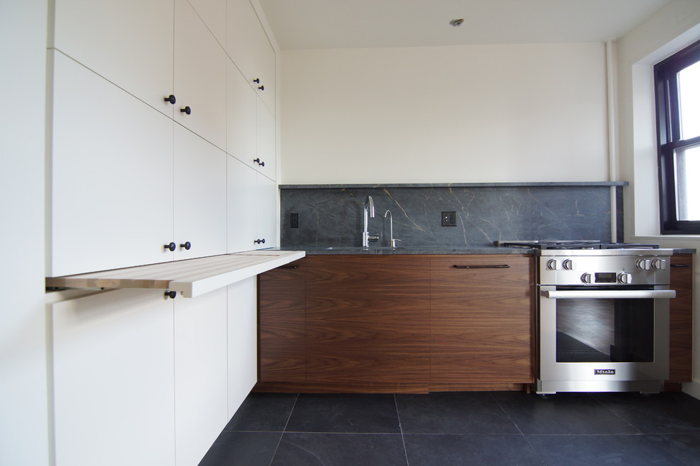 Small contemporary l-shaped open plan kitchen in New York with a single-bowl sink, flat-panel cabinets, white cabinets, limestone benchtops, grey splashback, stone slab splashback, stainless steel appliances, ceramic floors and no island.