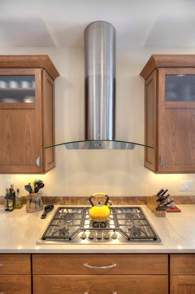 Mid-sized transitional u-shaped slate floor eat-in kitchen photo with an undermount sink, flat-panel cabinets, medium tone wood cabinets, brown backsplash, stone tile backsplash, stainless steel appliances, an island and quartz countertops
