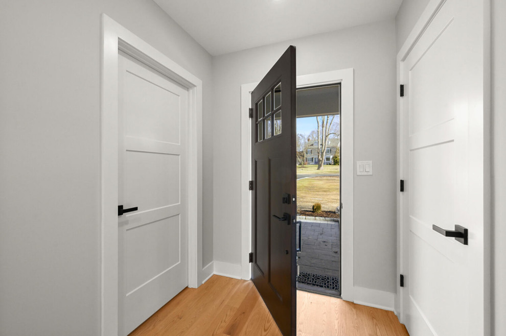 Design ideas for a large rural foyer in New York with grey walls, light hardwood flooring, a single front door and a black front door.