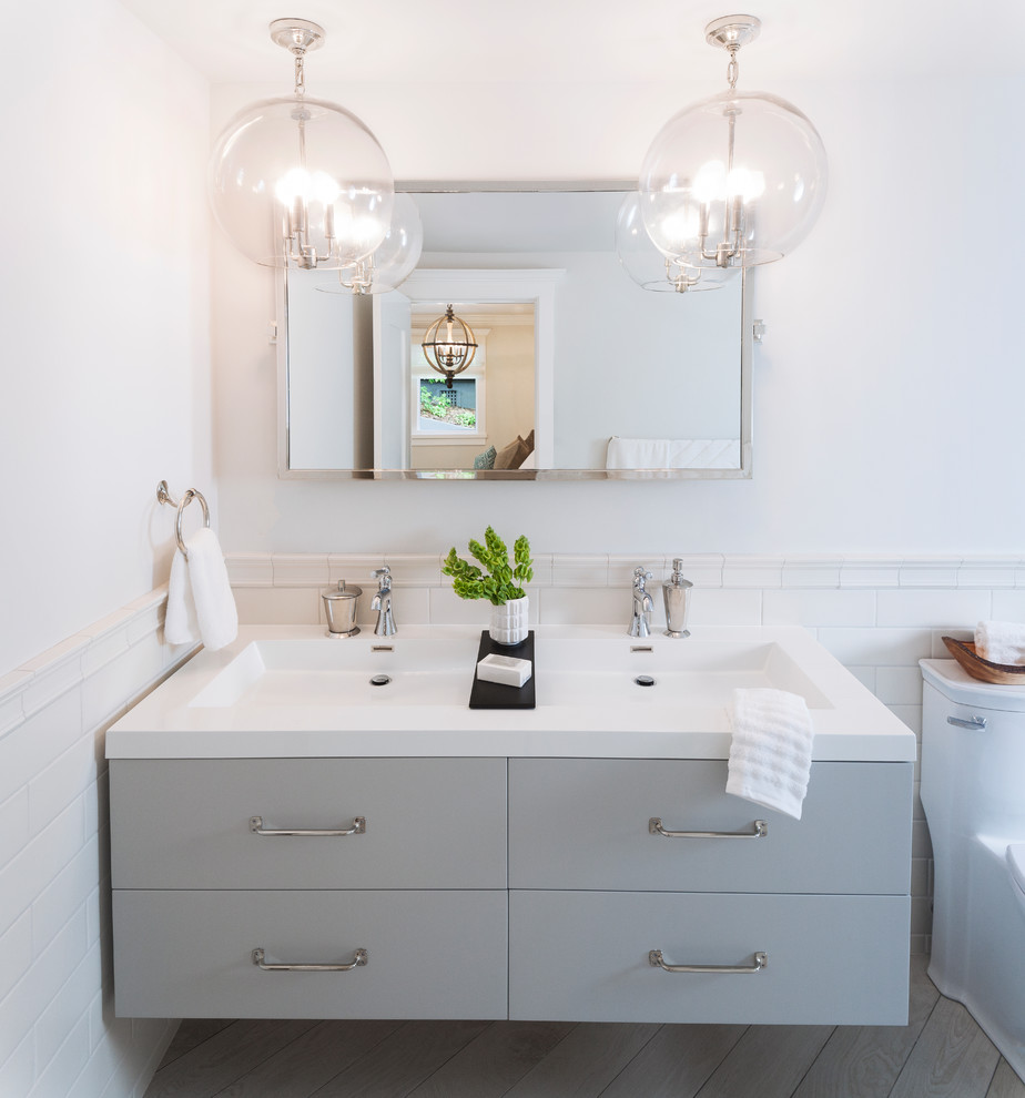Mid-sized contemporary master bathroom in San Francisco with flat-panel cabinets, distressed cabinets, a curbless shower, a one-piece toilet, white tile, ceramic tile, grey walls, ceramic floors, an undermount sink, onyx benchtops, grey floor and an open shower.