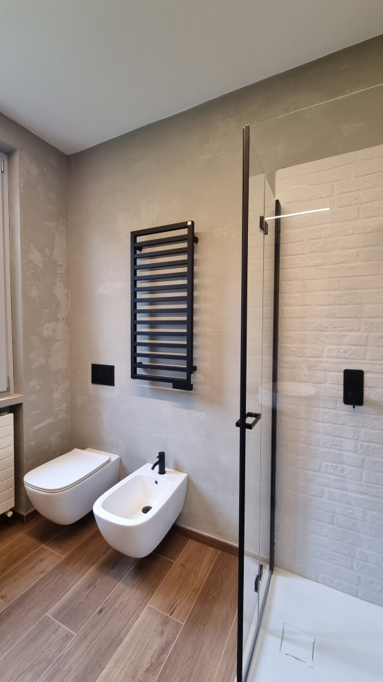 Design ideas for a small industrial cloakroom in Milan with flat-panel cabinets, grey cabinets, a wall mounted toilet, beige tiles, beige walls, porcelain flooring, a vessel sink, wooden worktops, brown floors, beige worktops, a floating vanity unit, a drop ceiling and brick walls.