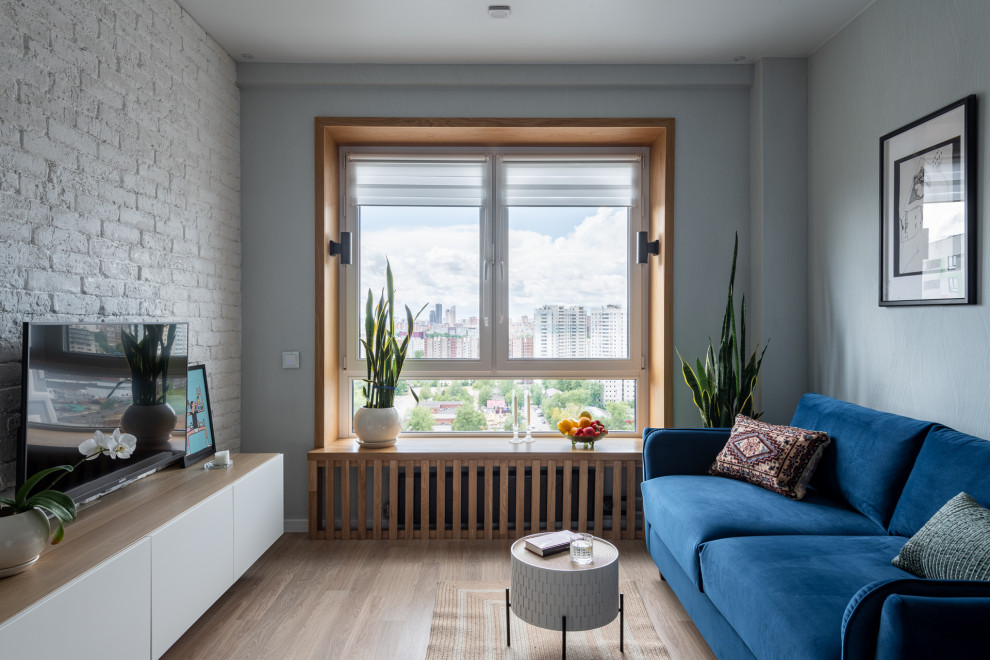 Modelo de salón cerrado y gris y blanco actual de tamaño medio con paredes grises, suelo de madera en tonos medios, televisor colgado en la pared, suelo beige y papel pintado