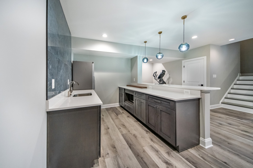 Bild på en mellanstor vintage vita parallell vitt hemmabar med vask, med en undermonterad diskho, skåp i shakerstil, bruna skåp, granitbänkskiva, blått stänkskydd, stänkskydd i porslinskakel, vinylgolv och grått golv