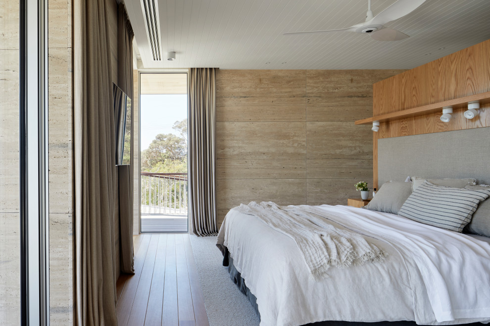 メルボルンにある中くらいなビーチスタイルのおしゃれな主寝室 (ベージュの壁、カーペット敷き、黒い床、塗装板張りの天井、羽目板の壁、アクセントウォール、白い天井) のインテリア