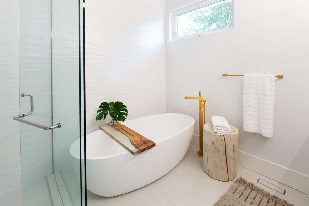 This is an example of a mid-sized modern master bathroom in Vancouver with flat-panel cabinets, white cabinets, a freestanding tub, a curbless shower, a one-piece toilet, white tile, ceramic tile, white walls, porcelain floors, an undermount sink, engineered quartz benchtops, grey floor, a hinged shower door and grey benchtops.