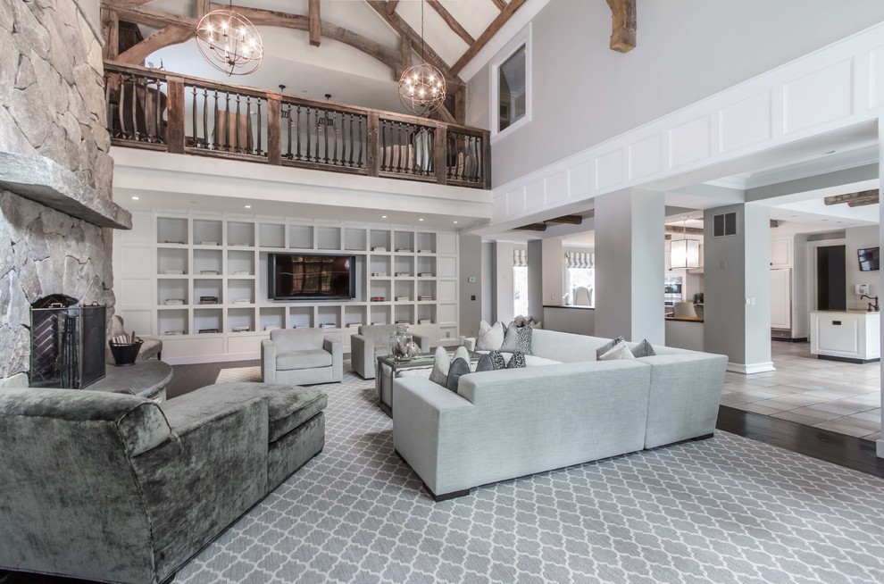 Photo of a traditional loft-style living room in Boston with grey walls, carpet, a standard fireplace, a stone fireplace surround and a built-in media wall.