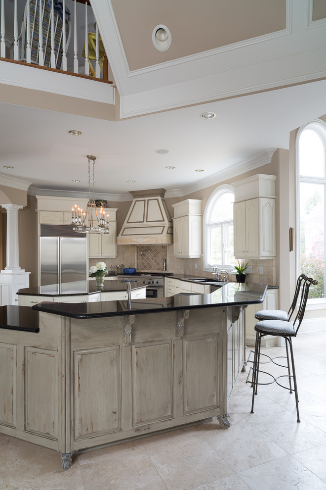 Design ideas for a large transitional u-shaped eat-in kitchen in Atlanta with an undermount sink, raised-panel cabinets, white cabinets, granite benchtops, beige splashback, stone tile splashback, stainless steel appliances, ceramic floors and multiple islands.