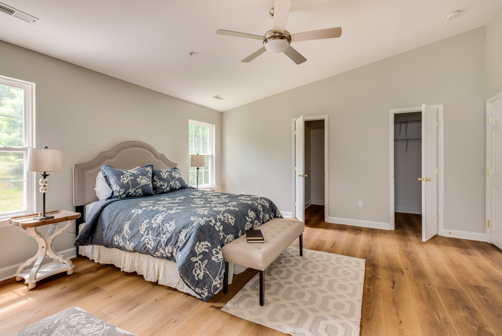 Expansive contemporary master bedroom in Baltimore with vinyl floors, yellow floor and grey walls.