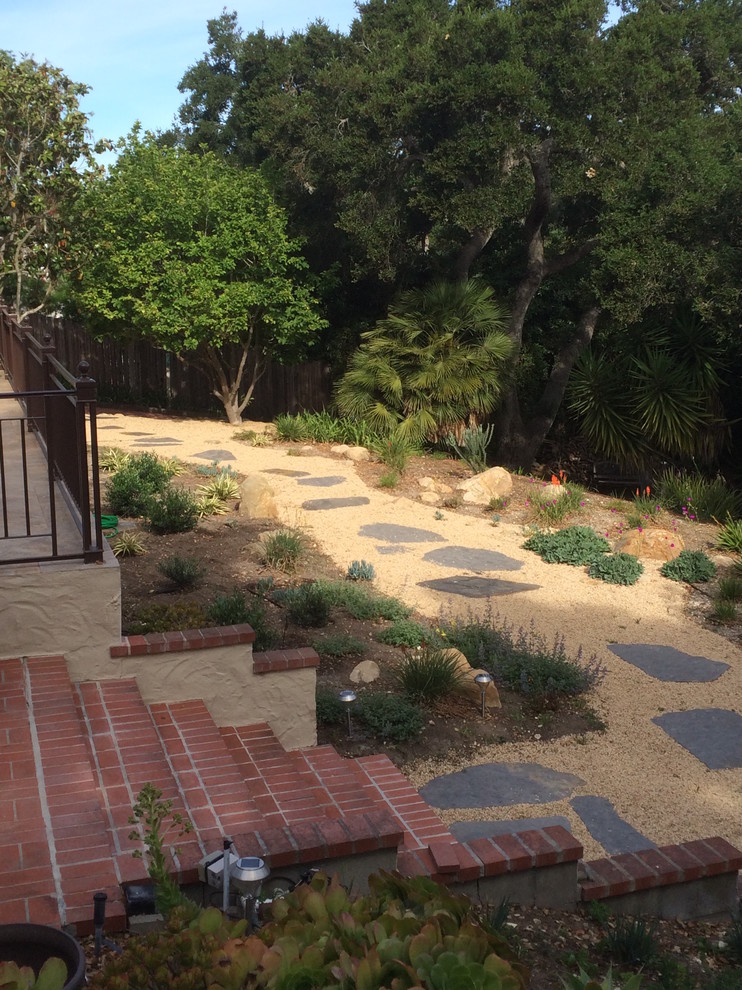 Inspiration for a small mediterranean backyard full sun xeriscape in Santa Barbara with a garden path and natural stone pavers.