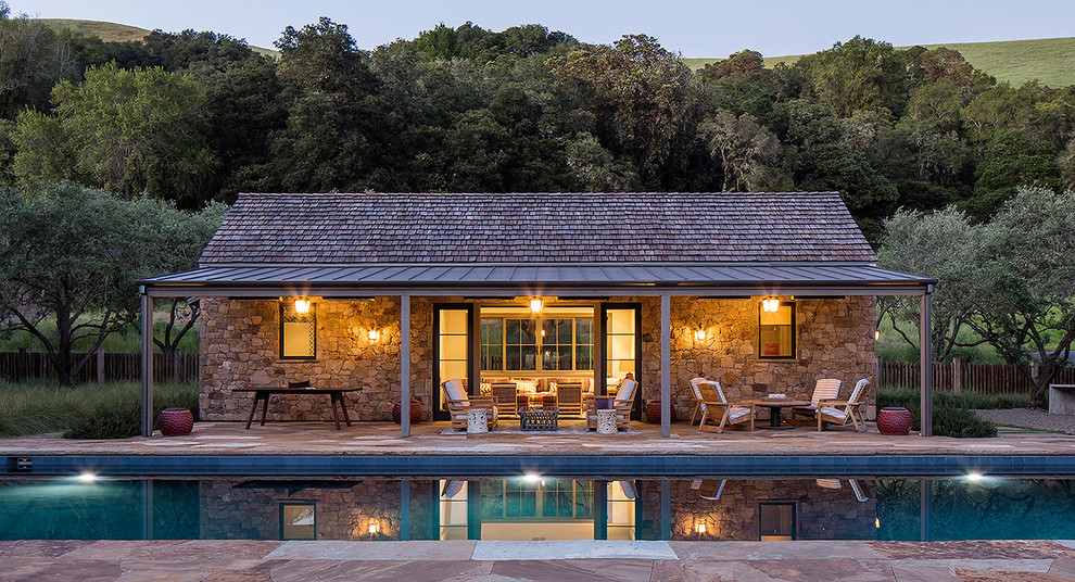 This is an example of a country backyard rectangular lap pool in San Francisco with a pool house.