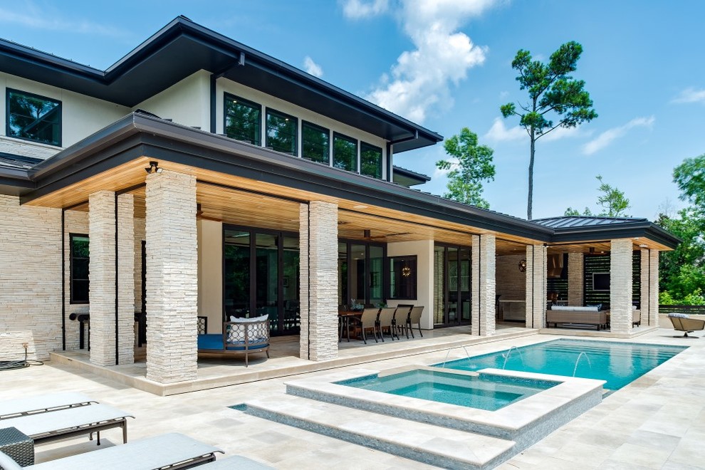 This is an example of a mid-sized midcentury backyard rectangular infinity pool in Wilmington with a hot tub and natural stone pavers.