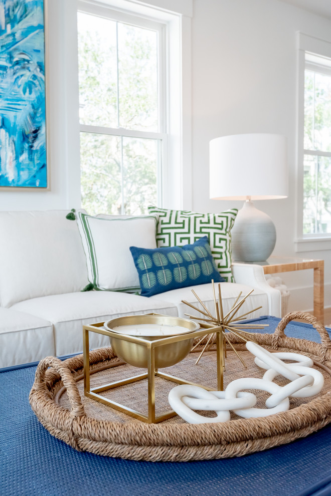 Design ideas for a mid-sized tropical open concept living room in Charleston with white walls, light hardwood floors and a wall-mounted tv.
