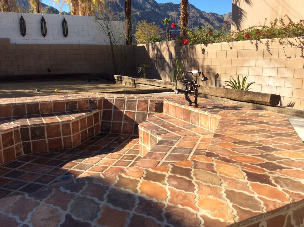 This is an example of a mid-sized mediterranean backyard patio in Los Angeles with an outdoor shower, tile and no cover.