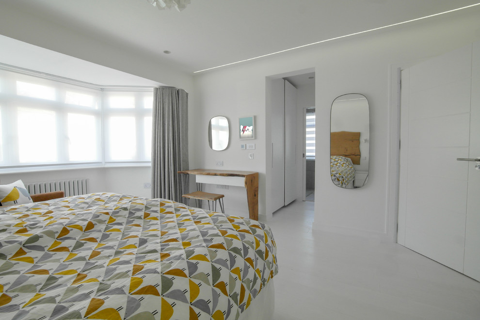Photo of a large contemporary bedroom in London with white walls, light hardwood floors and white floor.