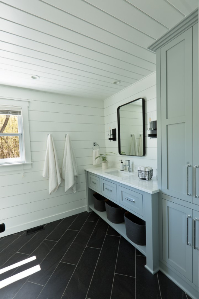 Design ideas for a rural bathroom in Minneapolis with recessed-panel cabinets, a corner shower, ceramic flooring, engineered stone worktops, a hinged door, a single sink, a built in vanity unit, a timber clad ceiling and tongue and groove walls.