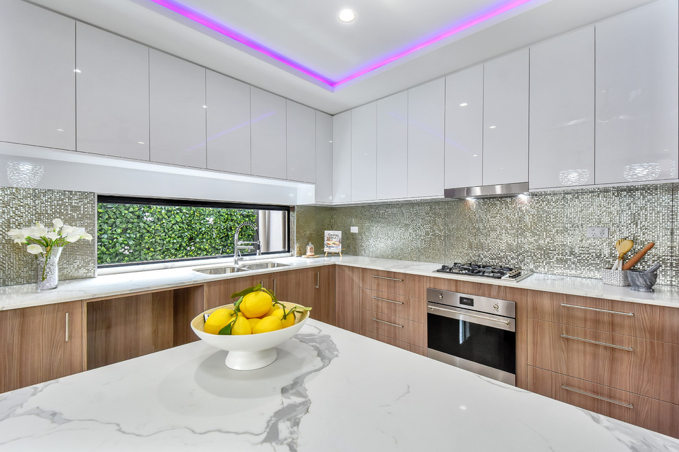 Large contemporary l-shaped eat-in kitchen in Darwin with a double-bowl sink, recessed-panel cabinets, medium wood cabinets, quartzite benchtops, metallic splashback, mosaic tile splashback, stainless steel appliances, porcelain floors and with island.