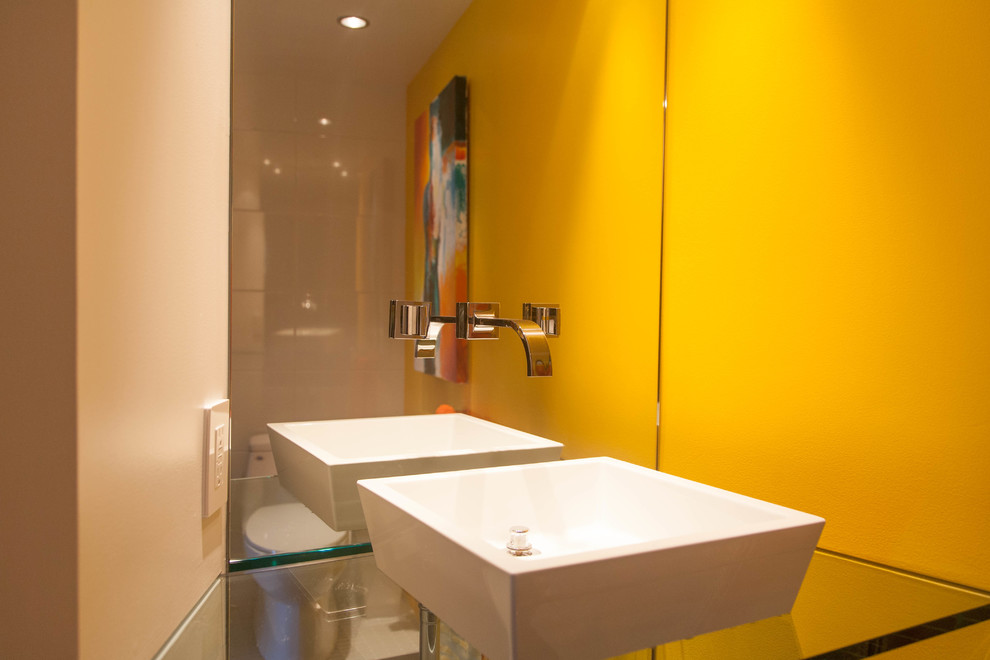 Photo of a large modern kids bathroom in San Francisco with a vessel sink, open cabinets, glass benchtops, a corner shower, a one-piece toilet, yellow walls and slate floors.