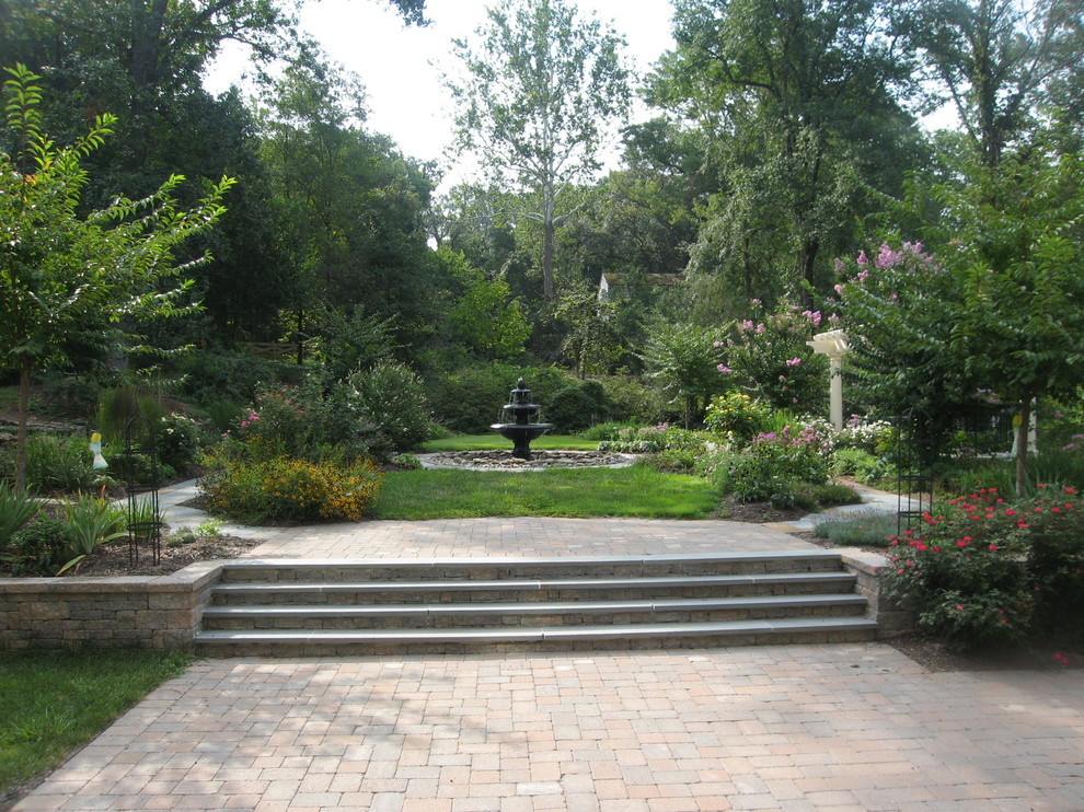 Expansive traditional front yard full sun formal garden in Richmond with a water feature and natural stone pavers for spring.