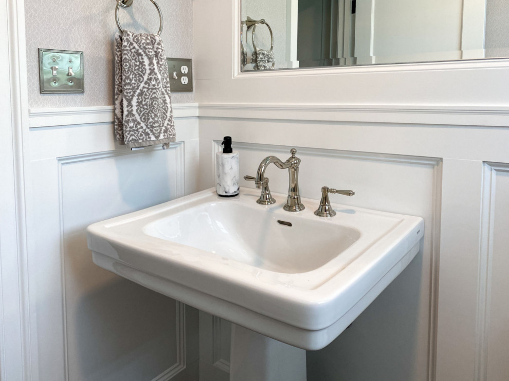 Esempio di un bagno di servizio classico con WC a due pezzi, pavimento in gres porcellanato, lavabo a colonna, pavimento nero e carta da parati