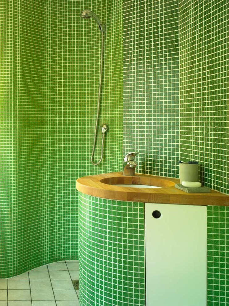 Inspiration for a small contemporary 3/4 bathroom in London with wood benchtops, a drop-in sink, medium wood cabinets, an open shower, green tile, green walls and ceramic floors.