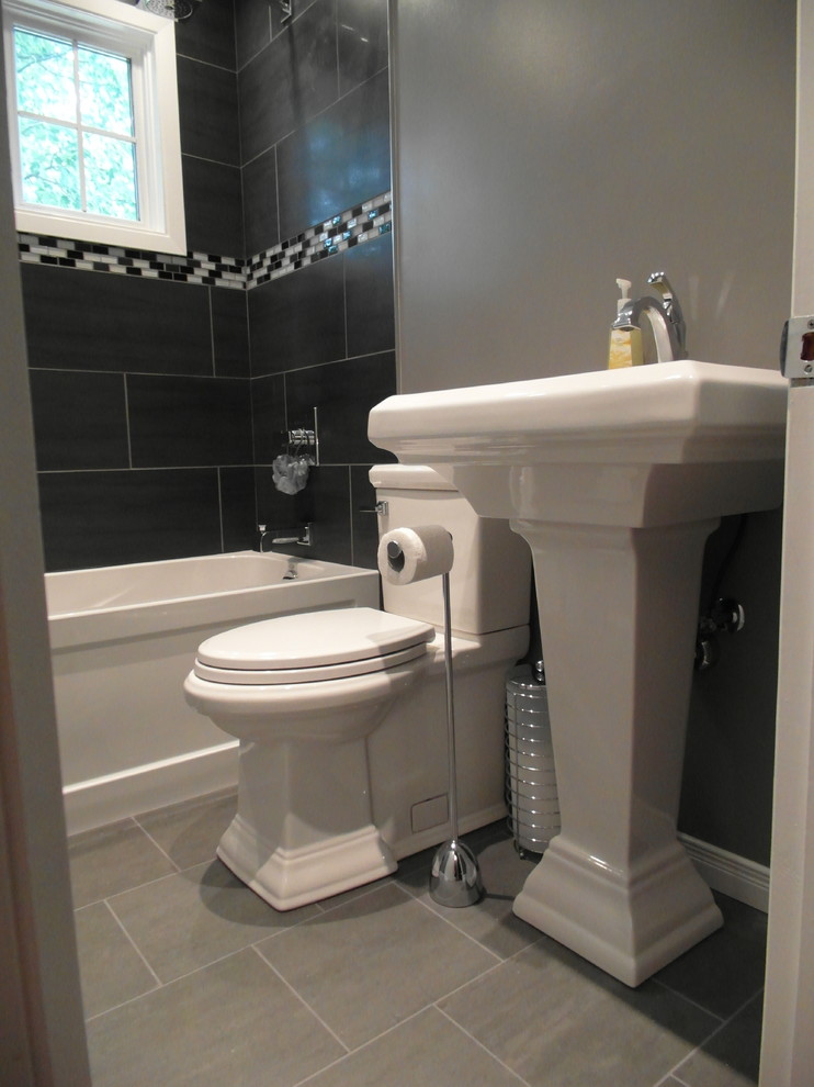 Inspiration for a small contemporary 3/4 bathroom in Ottawa with an alcove tub, a shower/bathtub combo, a two-piece toilet, black tile, gray tile, multi-coloured tile, matchstick tile, black walls, porcelain floors and a pedestal sink.