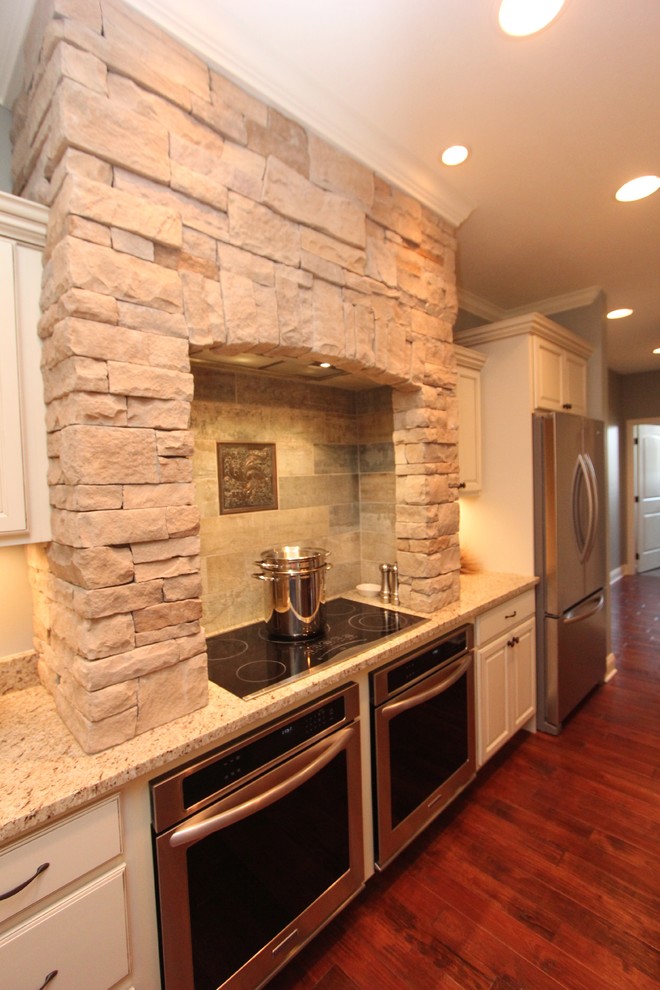 Inspiration for a large transitional u-shaped dark wood floor eat-in kitchen remodel with an undermount sink, raised-panel cabinets, white cabinets, granite countertops, stainless steel appliances and an island