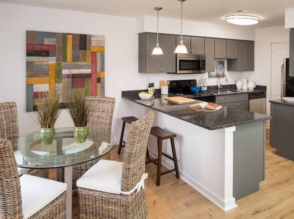 Inspiration for a small transitional single-wall light wood floor open concept kitchen remodel in Philadelphia with an undermount sink, shaker cabinets, green cabinets, granite countertops, stainless steel appliances and a peninsula