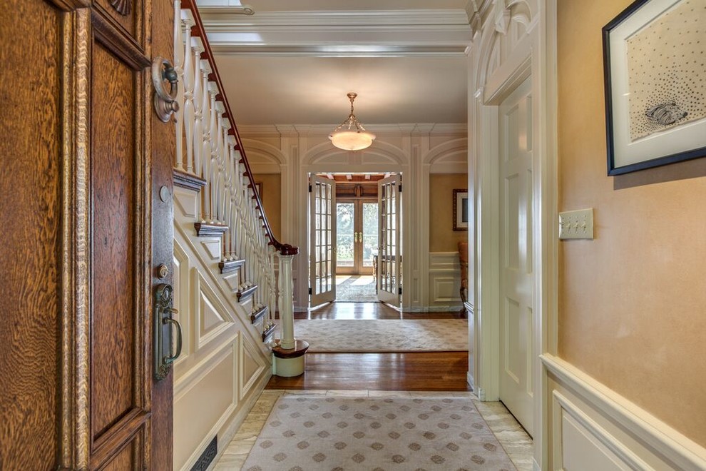 Inspiration for a large traditional hallway in Boston with beige walls and dark hardwood floors.