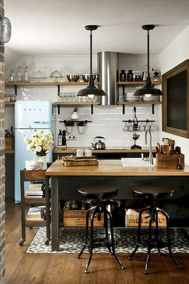 This is an example of a small industrial l-shaped eat-in kitchen in Columbus with a drop-in sink, recessed-panel cabinets, black cabinets, wood benchtops, white splashback, ceramic splashback, coloured appliances, medium hardwood floors, with island, brown floor and brown benchtop.
