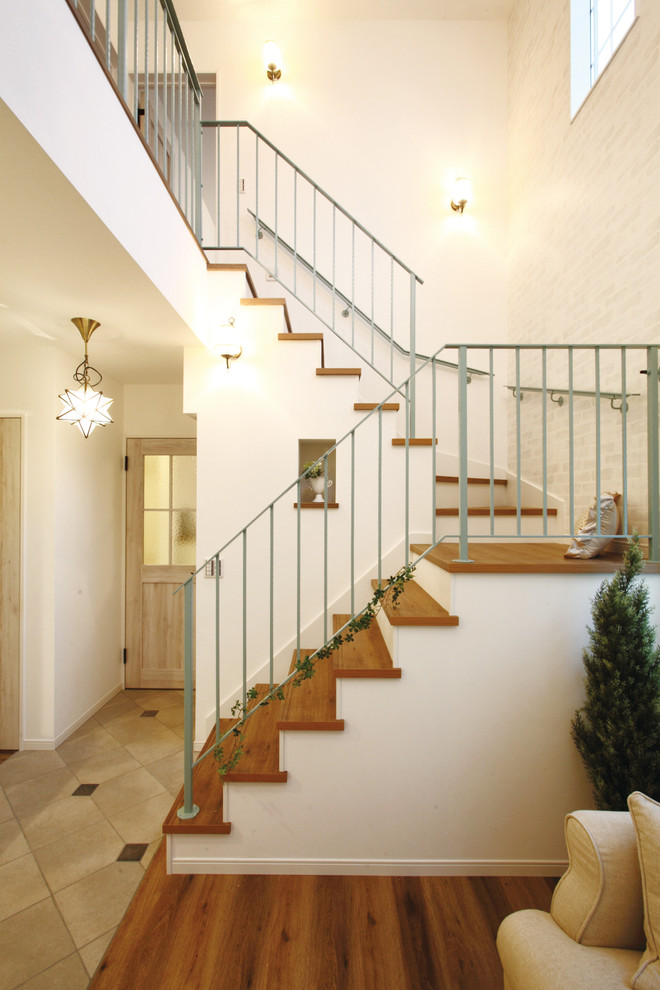 Inspiration for a transitional wood l-shaped staircase in Other with metal railing.