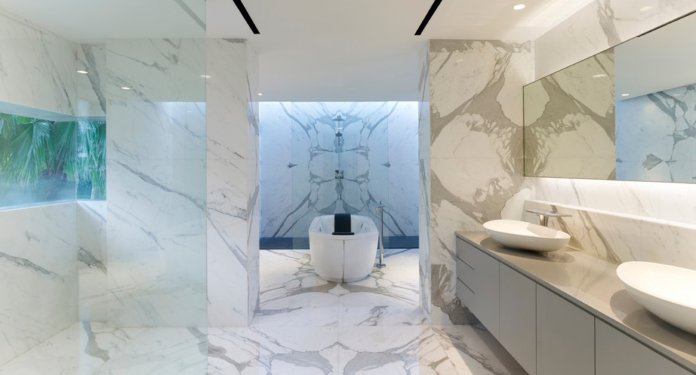 Inspiration for a contemporary bathroom in Singapore with marble floors, a vessel sink, a freestanding tub and marble.