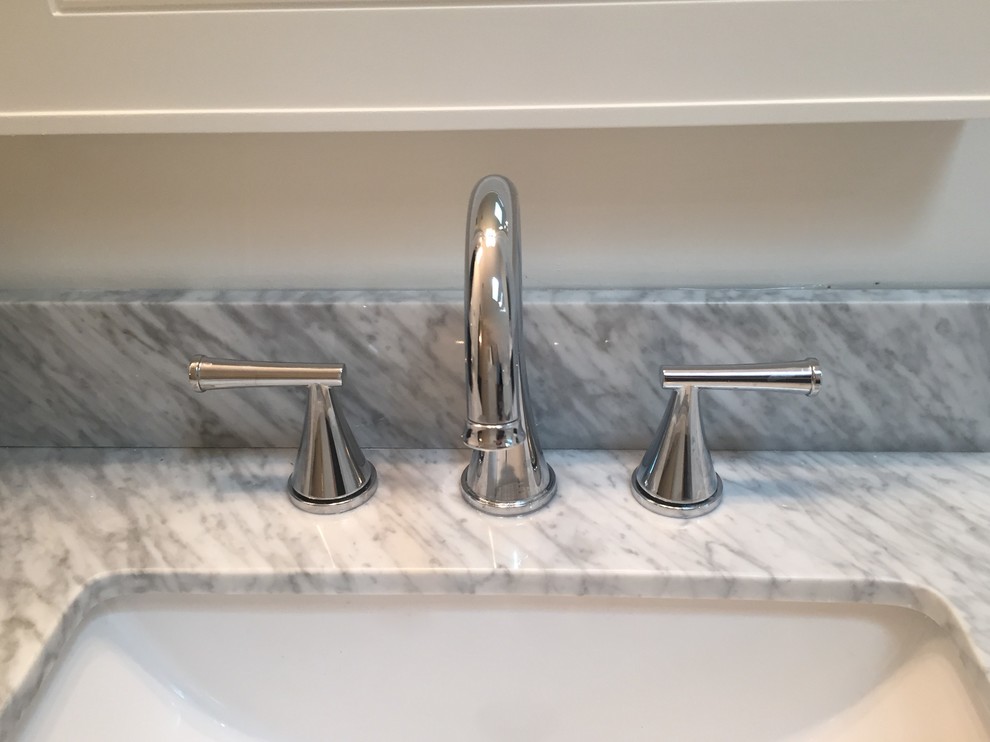 Home design - mid-sized transitional gray tile and porcelain tile porcelain tile home design idea in Indianapolis with flat-panel cabinets, white cabinets, a one-piece toilet, white walls, an undermount sink and marble countertops