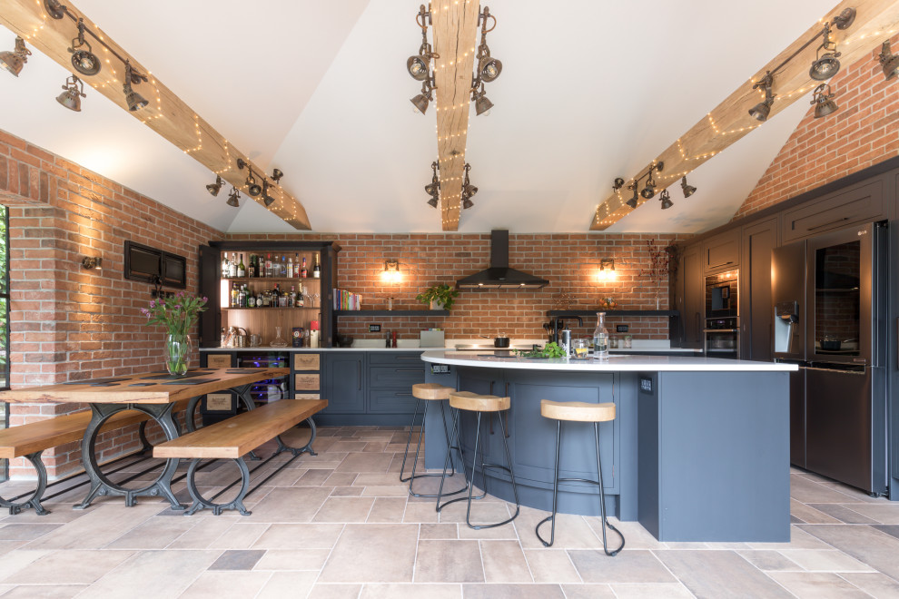 This is an example of a mid-sized industrial l-shaped eat-in kitchen in London with blue cabinets, solid surface benchtops, with island and white benchtop.
