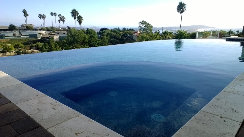 This is an example of a mid-sized contemporary custom-shaped infinity pool in San Diego with concrete pavers and a hot tub.