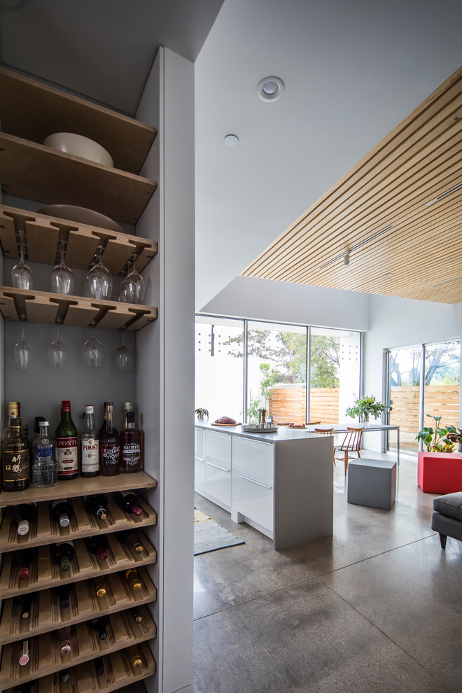 This is an example of a mid-sized contemporary wine cellar in Los Angeles with concrete floors, storage racks and grey floor.